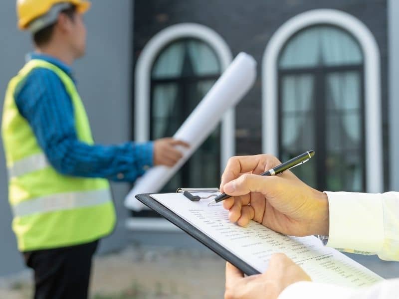 Construction team reviewing site documents during topographic survey planning for a property development project.